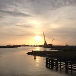 Sunset over port waterway with crane